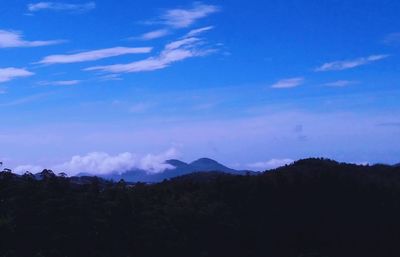 Scenic view of silhouette mountains against blue sky