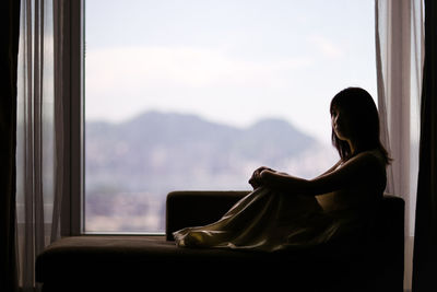 Woman sitting by window at home