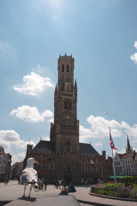 People at historic building against sky