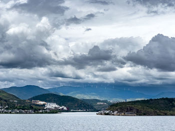 Scenic view of sea and mountains against sky