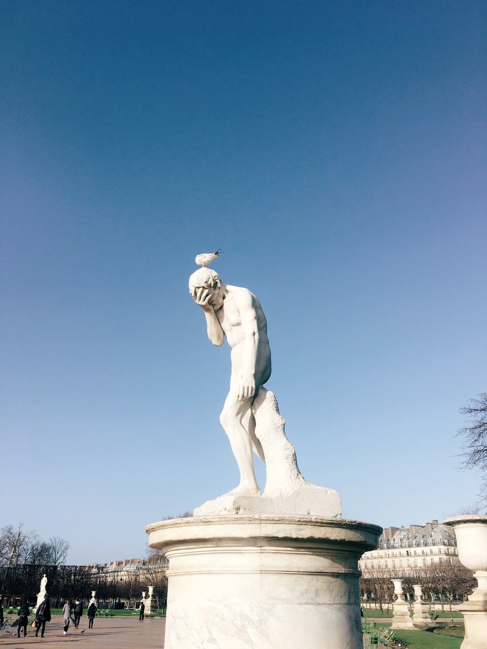 LOW ANGLE VIEW OF STATUE IN CITY AGAINST BLUE SKY