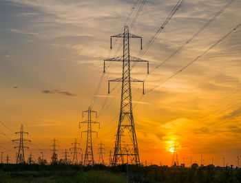 Low angle view of electricity pylon against romantic sky