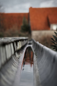 Close-up of railing in canal against building