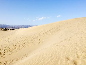 Sand dunes in desert against sky