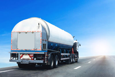 Vehicle on road against blue sky