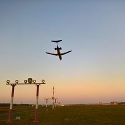 Airplane flying in sky at sunset