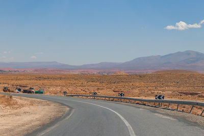 Road amidst desert against sky