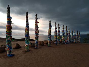 Multi colored umbrellas on beach against sky at sunset