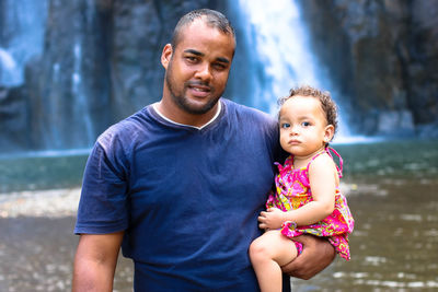 Portrait of father and son against water