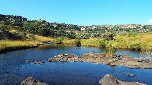 Scenic view of lake against clear blue sky