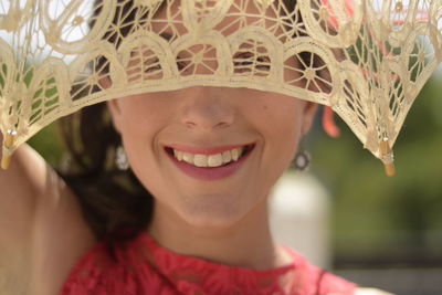 Close-up portrait of smiling woman seen from umbrella