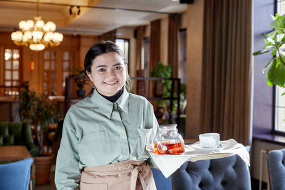 Portrait of smiling man standing in restaurant