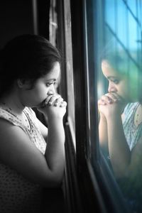 Girl looking through window