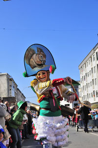 People at town square against clear blue sky