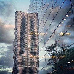 Low angle view of modern building against cloudy sky