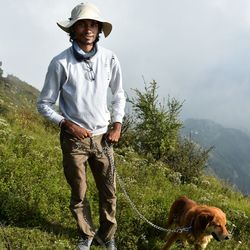 Full length portrait of young man standing against plants