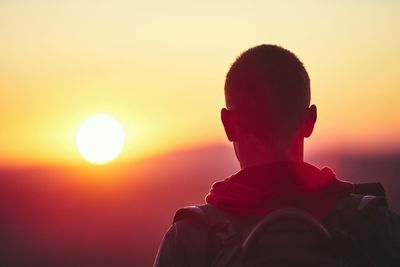 Rear view of boy looking at sunset