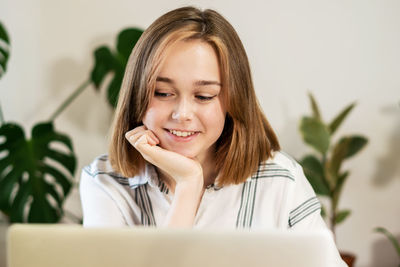 Girl using a computer for study online at home. remote work or study concept.