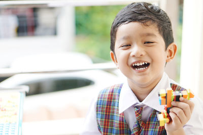 Portrait of smiling boy holding camera