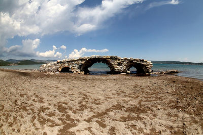 Scenic view of sea against sky with an ancient roman bridge near urla in turkey