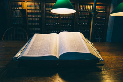 Open book on table in illuminated room