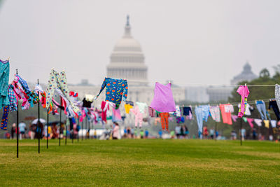 Multi colored flags on field against clear sky