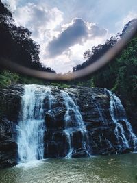 Scenic view of waterfall against sky