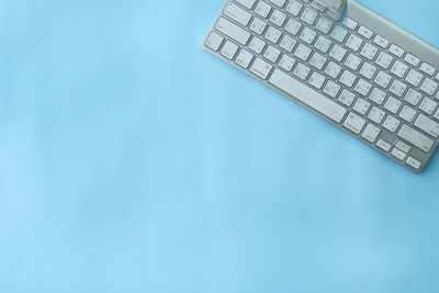 Close-up of computer keyboard against blue sky