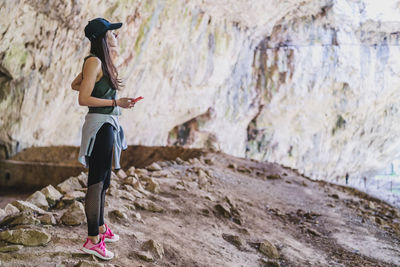 Side view of woman standing on rock