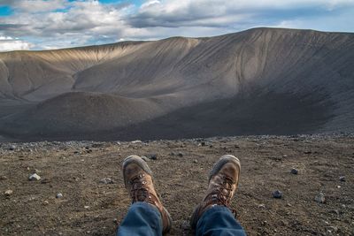 Low section of man on mountain against sky