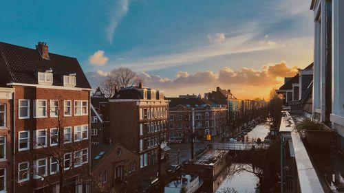 Buildings in city against cloudy sky