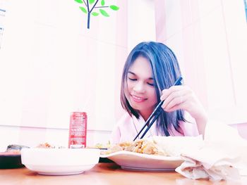 Young woman having food at table