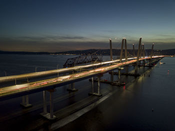 Bridge over river against sky during sunset