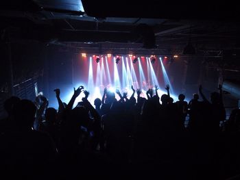 Silhouette crowd at illuminated music concert