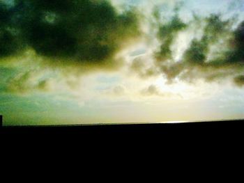 Silhouette of landscape against cloudy sky