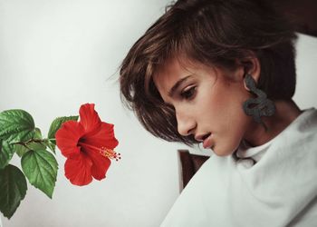 Close-up portrait of woman with red flower