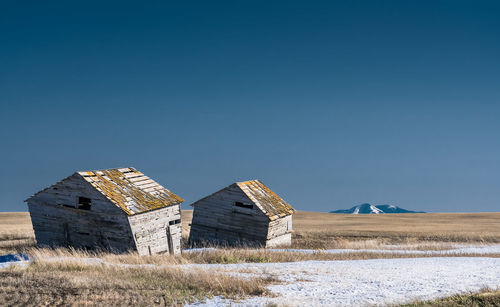 Abandoned house on field against clear sky