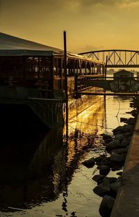 Bridge over river against sky during sunset