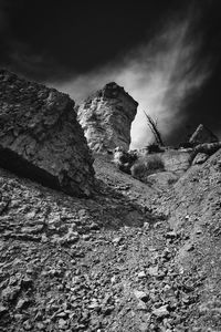 Low angle view of rock formation on land against sky