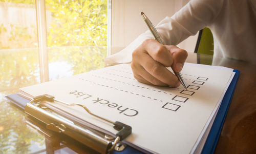 Midsection of woman writing on paper