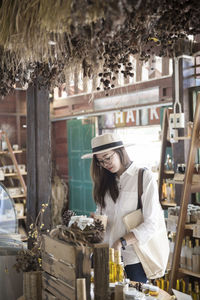 Young woman having drink while standing in shop