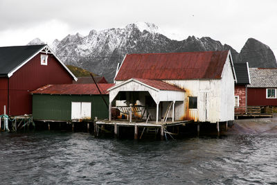 Houses by buildings against sky during winter