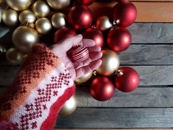 Cropped hand of woman holding bauble over table