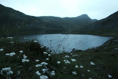 Scenic view of lake by mountains against sky