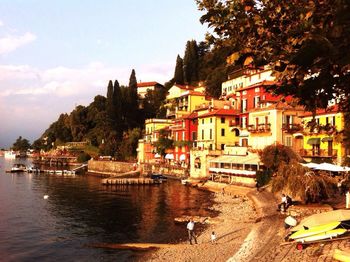 Town by river against sky