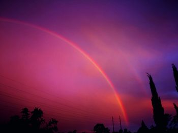 Low angle view of rainbow against sky at sunset