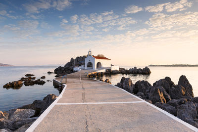 Scenic view of sea by building against sky during sunset