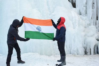 People standing on snow covered landscape during winter