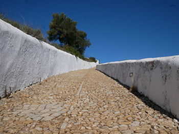 Surface level of road against clear blue sky