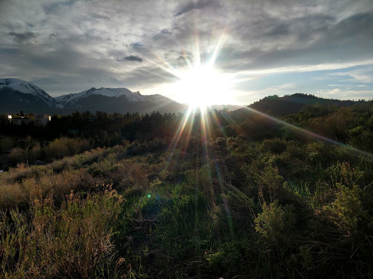 SUNLIGHT STREAMING ON MOUNTAIN AGAINST SKY